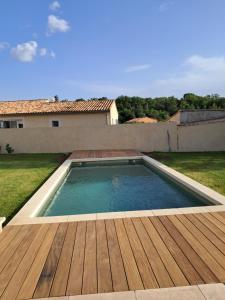 einem Pool mit Holzterrasse und einem Haus in der Unterkunft Villa SOFIA in Saint-Saturnin-dʼApt