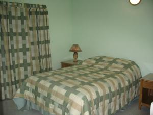 a bedroom with a bed and a lamp on a table at Anne Marie Villas in Castries