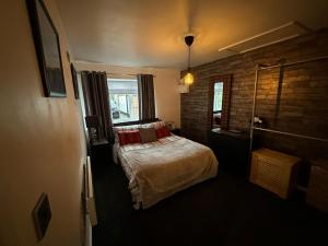 a bedroom with a bed and a brick wall at Shropshire Guesthouse in Wolverhampton