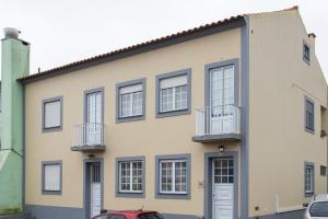 a building with windows and a red car parked in front at Casa Espaçosa perto de Angra in Angra do Heroísmo