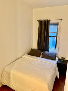 a bed with two pillows on it in a bedroom at Park Ave Apartments Midtown Next to Times Square in New York