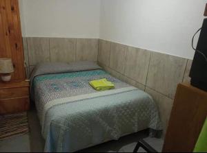 Un dormitorio con una cama con una toalla amarilla. en Buen Descanso, en Malargüe