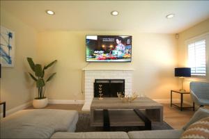 uma sala de estar com lareira e uma televisão na parede em Cozy 3BR: AC & Great Location em San José