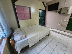 Habitación pequeña con cama y baño. en Hostal el porrón, en Suchitoto