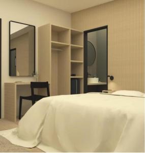 1 dormitorio con 1 cama blanca con silla y 2 espejos en Hestheimar, en Hella