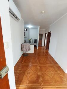 an empty room with a wooden floor and white walls at Departamentos de la Costa in Machala