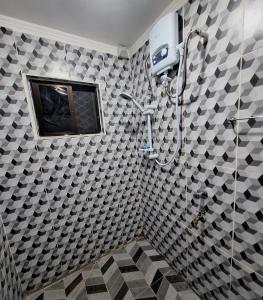 a bathroom with a shower with black and white tiles at Mount Olivet House in Suva