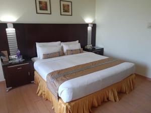 1 cama grande en una habitación de hotel con 2 mesas en The Red Maple Mashal, en Indore