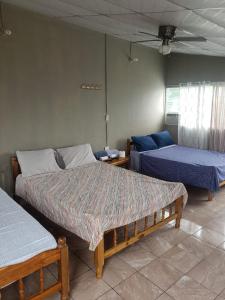 um quarto com 2 camas e um sofá em Hostal el porrón em Suchitoto