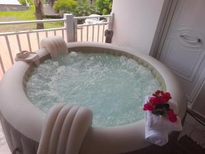 einen Whirlpool auf einem Balkon mit Blumen in der Unterkunft VillaBadlou "Lodge Ti-Kaco Vanille" in Trois-Rivières