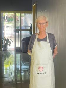 an older woman in apron standing in a room at Hospedagem Dona Ester in Pomerode