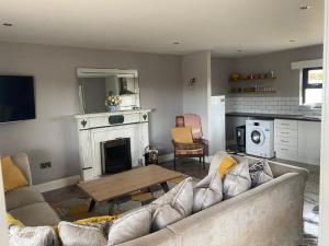 a living room with a couch and a fireplace at Thornstown Gate Cottage in Portglenone
