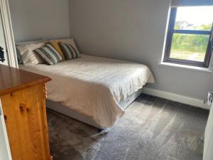 a small bedroom with a bed and a window at Thornstown Gate Cottage in Portglenone
