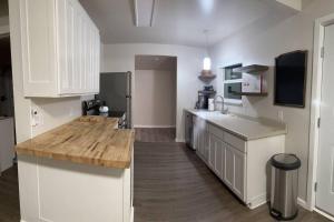 a kitchen with white cabinets and a wooden counter top at River's Edge Retreat / Close I-5 in Gold Hill