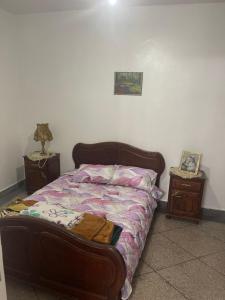 a bed in a room with two nightstands and aitures at Appartement Casablanca in Casablanca