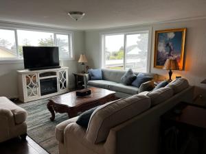 Una sala de estar con un sofá y un televisor. en Idlewild Manor Vacation home, en Gold Beach