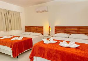- une chambre avec 2 lits et des serviettes dans l'établissement Solar Água Pipa- Summer Pipa, à Pipa