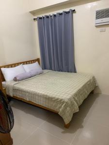 ein Schlafzimmer mit einem Bett mit einem blauen Vorhang in der Unterkunft 2BR unit @ CHATEAU ELYSEE vendome tower 6th flr in Manila