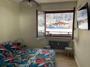 - une chambre avec un lit et une fenêtre dans l'établissement Résidence Bois du Bouchet, appartement vue montagne, calme, parking gratuit, proche centre, à Chamonix-Mont-Blanc