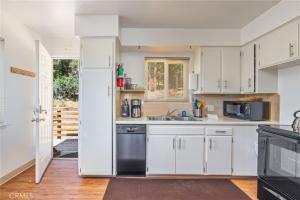 uma cozinha com armários brancos e uma máquina de lavar louça preta em Mountain View, near Yosemite & Bass Lake, BBQ, Fireplace,EVC em Oakhurst