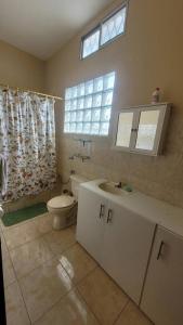 uma casa de banho com um WC, um lavatório e uma janela em EVA Beach House em Crucita