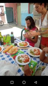 un grupo de personas de pie alrededor de una mesa con platos de comida en Casa Zope, en Panajachel