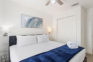 a white bedroom with a bed with a blue blanket at Allure - Sleeps 8 - 3 BDM - Disney in Kissimmee +45 photos