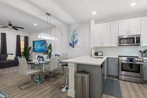 a kitchen and living room with white cabinets and a table at Allure - Sleeps 8 - 3 BDM - Disney in Kissimmee