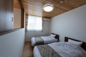 a bedroom with two beds and a window at Kawaguchiko Superba Vista Annex in Fujikawaguchiko +104 photos
