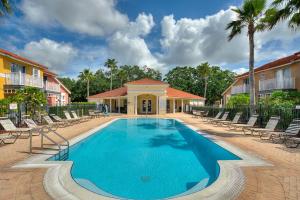 a swimming pool with chairs and a building at Allure - Sleeps 8 - 3 BDM - Disney in Kissimmee