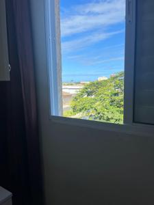 an open window with a view of a beach at Ohanacaiçara apartamento próximo à praia do Sesc, completo e com Wi-Fi. in Bertioga