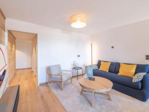 uma sala de estar com um sofá azul e uma mesa em Appartement Huez, 3 pièces, 4 personnes - FR-1-645-72 em LʼHuez