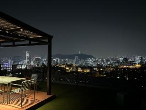 een tafel en stoelen op een balkon in de nacht bij Naksan Balcony in Seoul