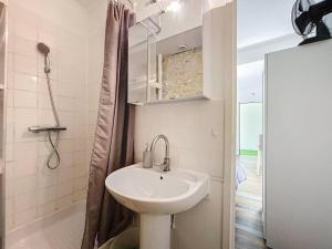 La salle de bains blanche est pourvue d'un lavabo et d'une douche. dans l'établissement Studio La Rochelle, 1 pièce, 2 personnes - FR-1-710-26, à La Rochelle