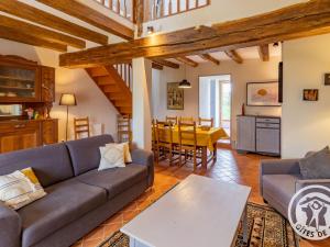 ein Wohnzimmer mit Couch und Tisch in der Unterkunft Gîte confortable 2 chambres avec jardin, animaux admis, Wifi, parking - FR-1-622-80 in Vihiers