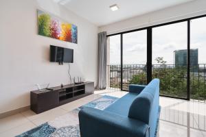 un soggiorno con divano blu e TV di NETFLIX STUDIO @ TREFOIL SETIA CITY a Setia Alam