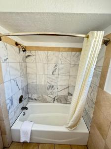 een badkamer met een bad en een douchegordijn bij Tamalpais Motel in Mill Valley