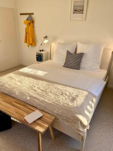 1 cama grande con sábanas blancas y almohadas en una habitación en Hotel Villa Klasen, en Wenningstedt