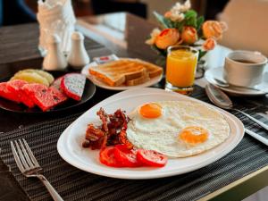um prato de pequeno-almoço com ovos, bacon e torradas em Ramada by Wyndham Bangkok Sukhumvit 11 em Bangkok