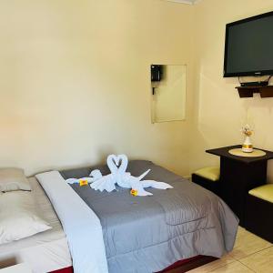 une chambre d'hôtel avec un lit avec deux animaux farcis dans l'établissement Pousada São Benedito, à Santo Antônio do Pinhal