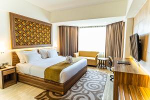 a hotel room with a large bed and a desk at Horison Ultima Bandung in Bandung