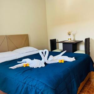 a bedroom with a bed with two swans on it at Pousada São Benedito in Santo Antônio do Pinhal