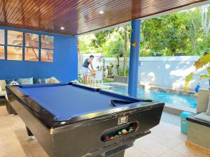 uma mesa de bilhar num quarto com piscina em Casa privada 4 habitaciones aires, piscina billar agua caliente 3 minutos de la playa em Río San Juan