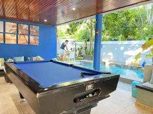 a pool table in a room with a swimming pool at Casa privada 4 habitaciones aires, piscina billar agua caliente 3 minutos de la playa in Río San Juan