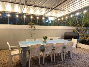 a dining table and chairs in a patio with lights at Casa privada 4 habitaciones aires, piscina billar agua caliente 3 minutos de la playa in Río San Juan