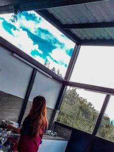 a woman sitting at a counter looking out of a window at SUITE STARS in Latacunga