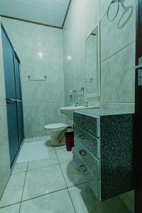 a bathroom with a sink and a toilet and a mirror at Pousada São Benedito in Santo Antônio do Pinhal