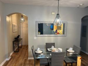 a dining room with a glass table and chairs at Vashay's Lovely vacation pad at Disney in Davenport +130 photos
