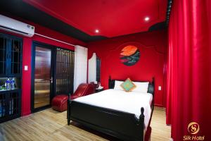 - une chambre rouge avec un lit et un rideau rouge dans l'établissement Silk Hotel near Tan Son Nhat Airport, à Hô-Chi-Minh-Ville