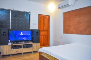 a room with a tv and a bed in it at Casa de Madera The Wooden House in Cabuyao